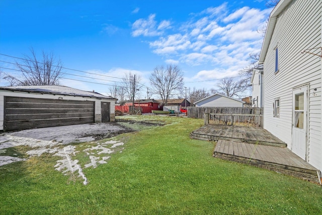 view of yard featuring an outbuilding, a garage, and a wooden deck