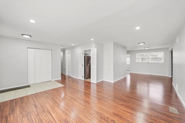 unfurnished living room featuring recessed lighting, visible vents, baseboards, and wood finished floors