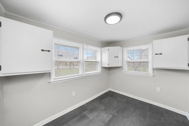 spare room featuring baseboards and crown molding