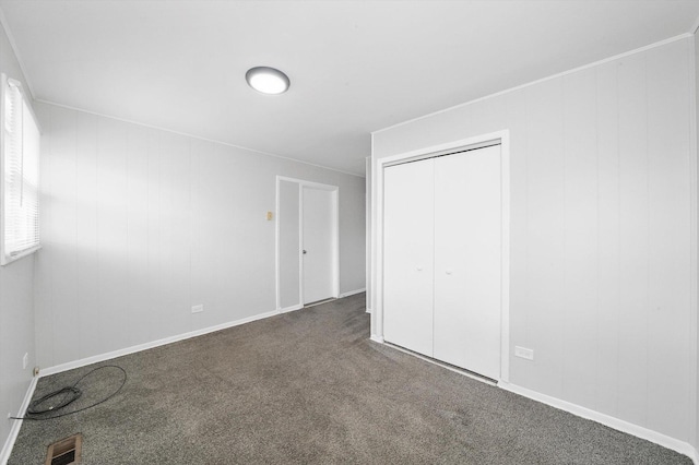 unfurnished bedroom with visible vents, carpet flooring, and a closet