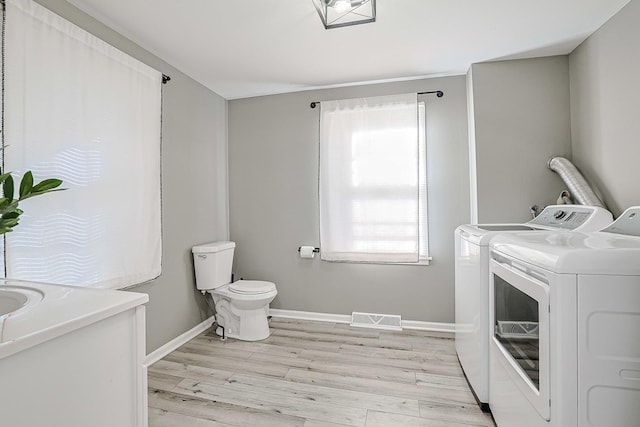 laundry area featuring light wood-type flooring and independent washer and dryer