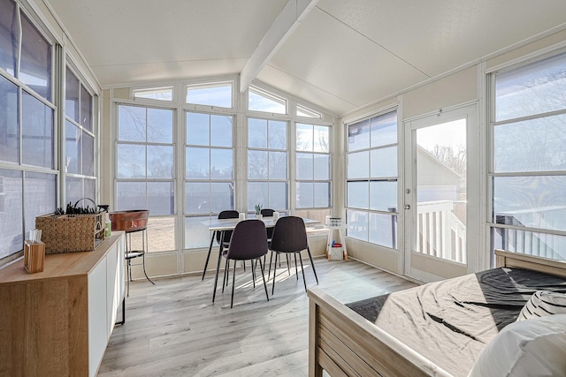 sunroom featuring lofted ceiling with beams