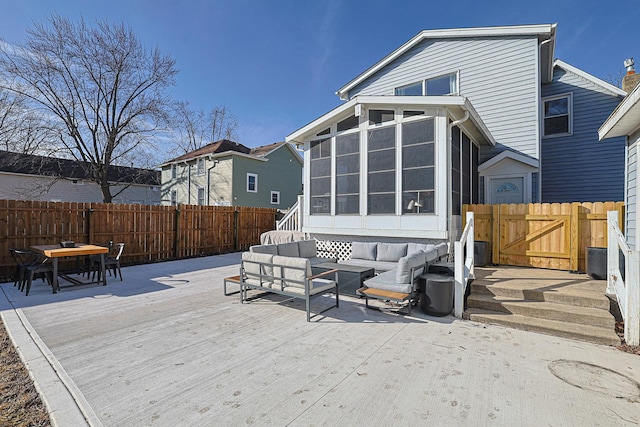 rear view of property featuring an outdoor hangout area, a deck, and a sunroom