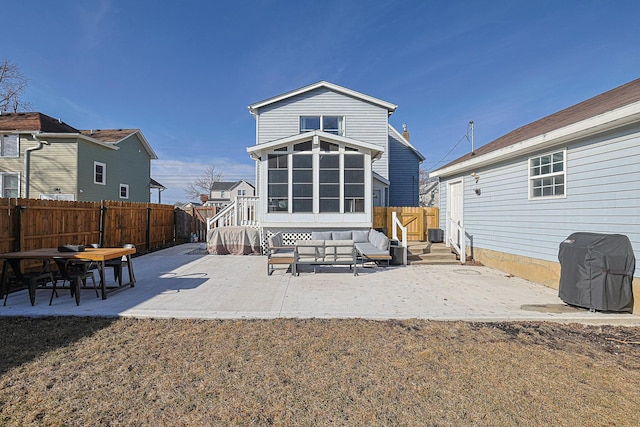 back of property with a lawn, a sunroom, and a patio