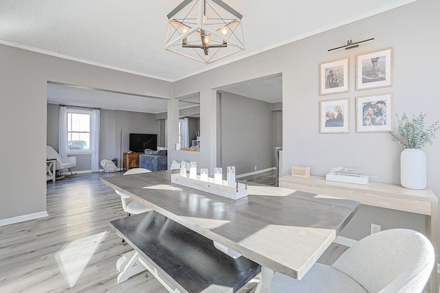 dining space with an inviting chandelier, hardwood / wood-style floors, ornamental molding, and a textured ceiling