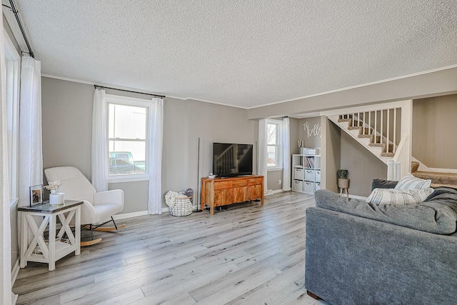 living room with crown molding, a textured ceiling, and light wood-type flooring