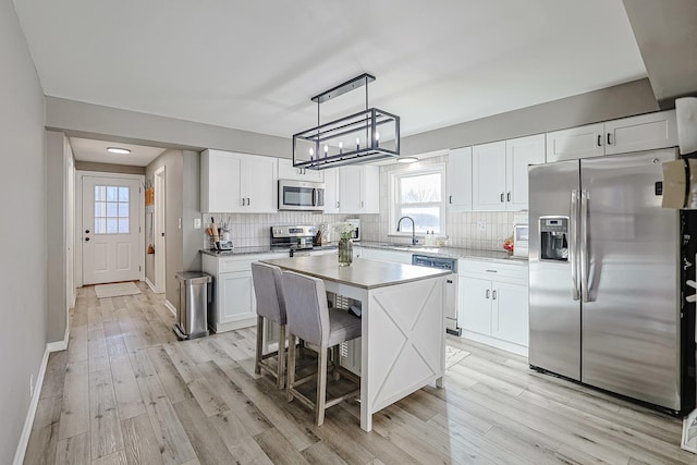 kitchen featuring stainless steel appliances, white cabinetry, and a center island