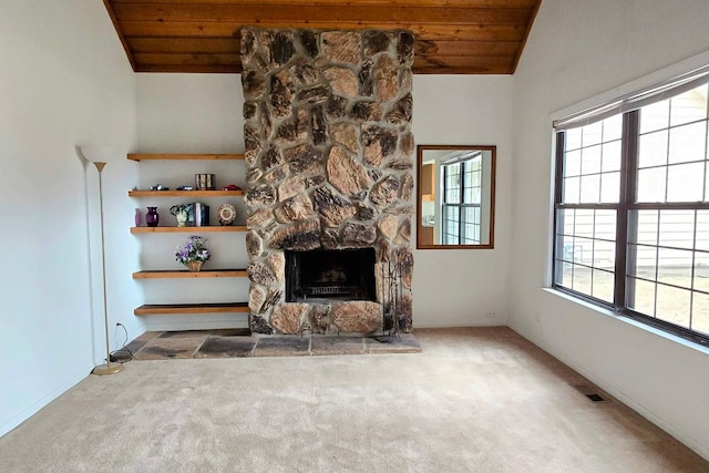 unfurnished living room with wood ceiling, a stone fireplace, vaulted ceiling, and carpet flooring