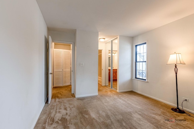 unfurnished bedroom with light carpet and ensuite bath