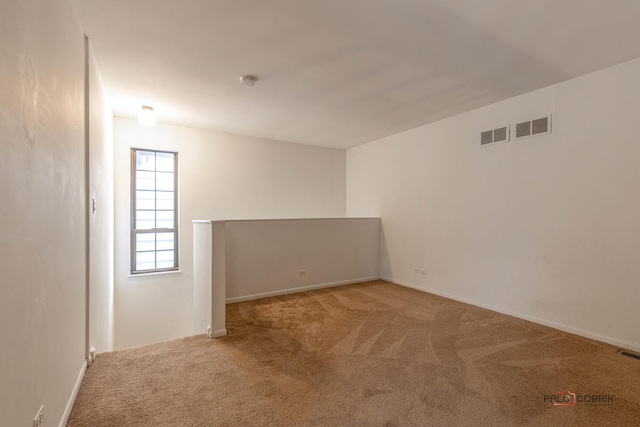 unfurnished room featuring light carpet