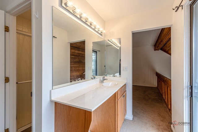 bathroom with vanity, vaulted ceiling with beams, and a shower with door