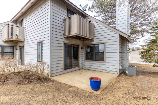 back of house with central AC, a patio, and a balcony