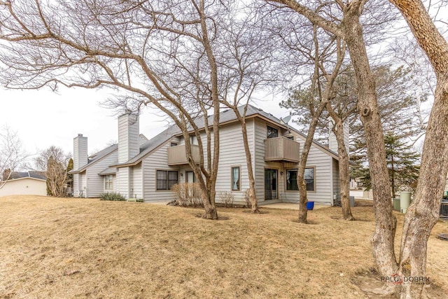 back of house with a balcony, a yard, and a patio area