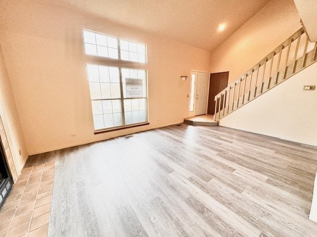 unfurnished living room featuring lofted ceiling and light hardwood / wood-style flooring