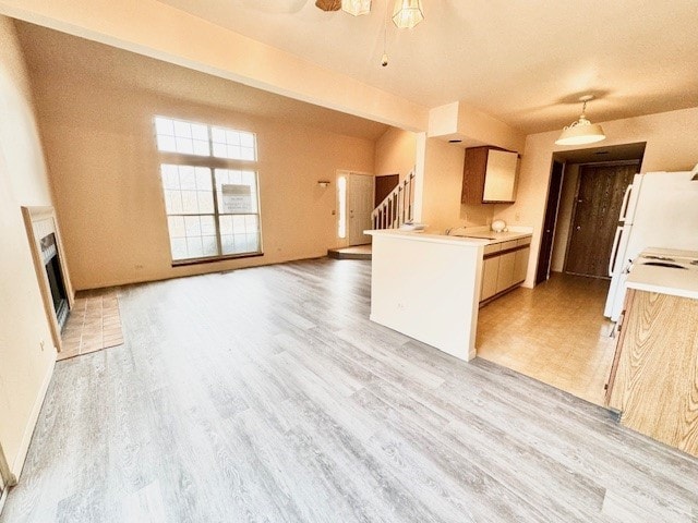 kitchen with ceiling fan, vaulted ceiling, white fridge, and light wood-type flooring