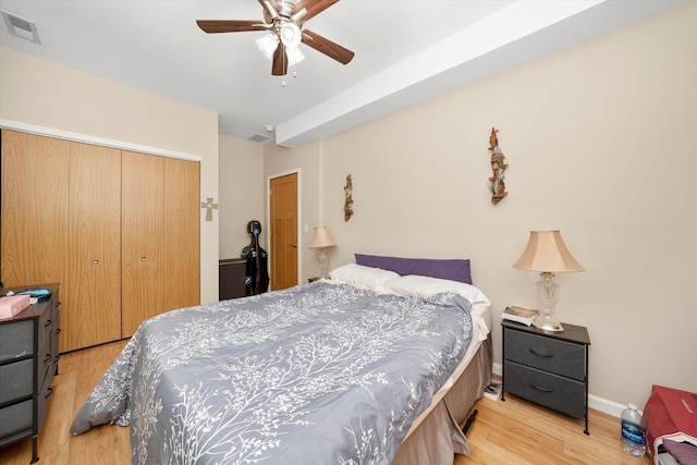 bedroom featuring a closet, visible vents, a ceiling fan, light wood-type flooring, and baseboards