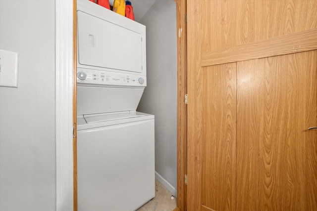 laundry room featuring stacked washer and dryer, laundry area, and baseboards