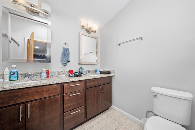 full bath featuring toilet, tile patterned flooring, double vanity, and a sink