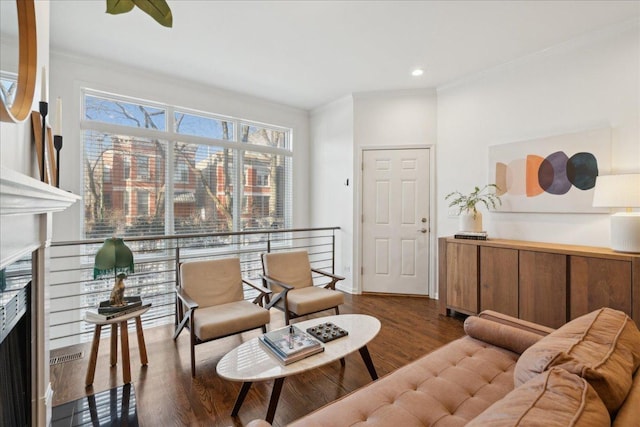 living room with crown molding, plenty of natural light, and dark hardwood / wood-style flooring