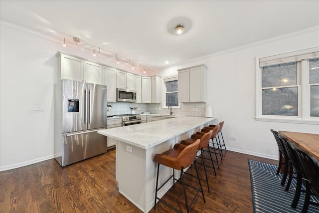 kitchen featuring backsplash, stainless steel appliances, light stone countertops, white cabinets, and kitchen peninsula