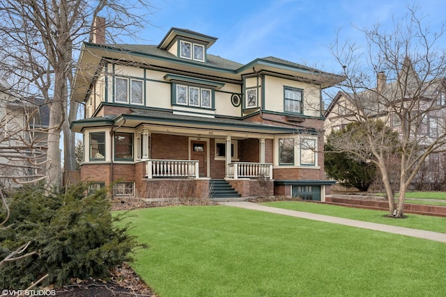 view of front of home featuring a chimney, brick siding, covered porch, and a front yard