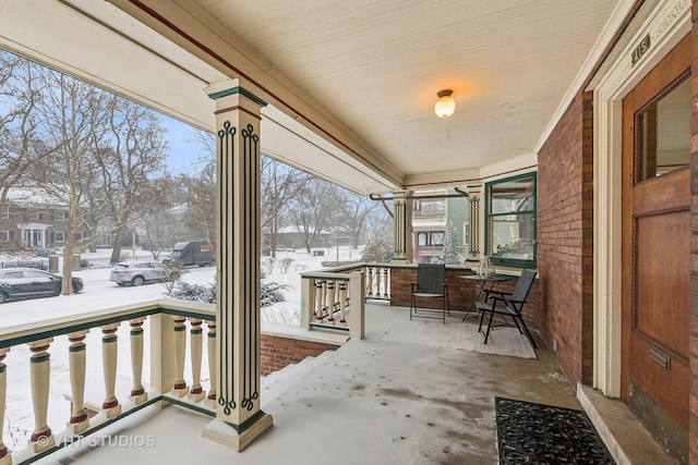 snow covered patio with a porch