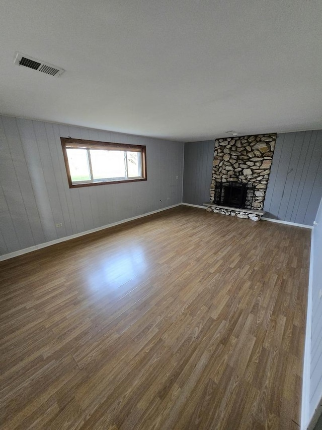 unfurnished living room featuring wood-type flooring and a fireplace