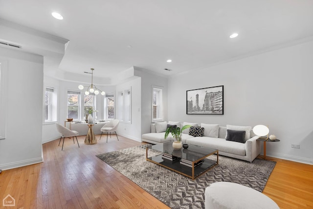 living room featuring light wood-type flooring, recessed lighting, baseboards, and ornamental molding