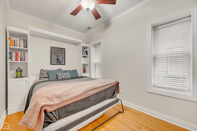 bedroom with ceiling fan, ornamental molding, light wood-type flooring, and baseboards