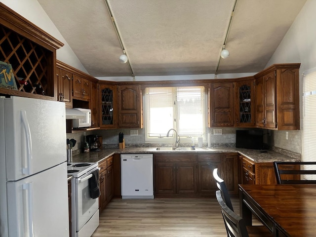 kitchen with lofted ceiling, sink, white appliances, a textured ceiling, and light wood-type flooring