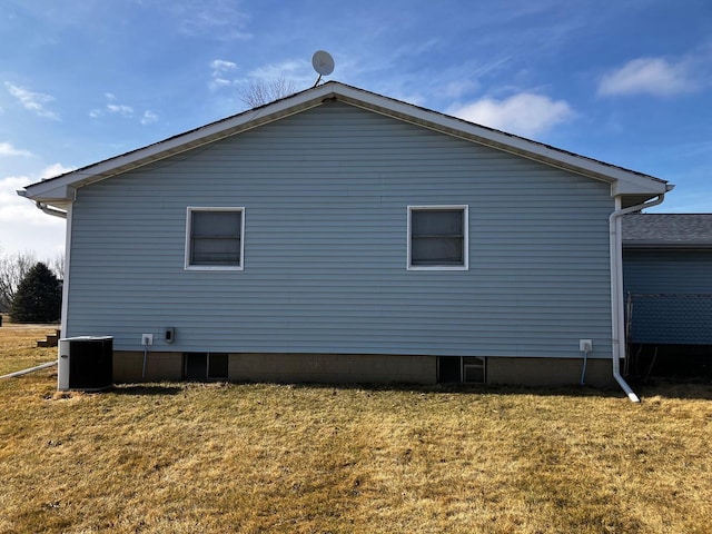 view of side of home with a yard and central AC unit