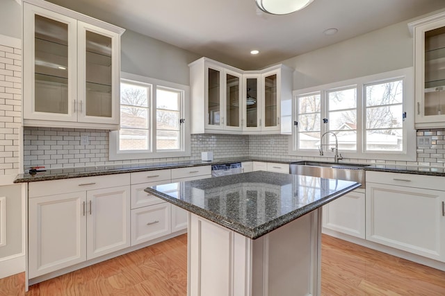 kitchen featuring dark stone counters, a kitchen island, and white cabinets