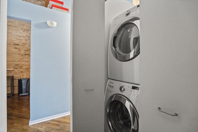 washroom featuring dark wood-type flooring and stacked washer and clothes dryer