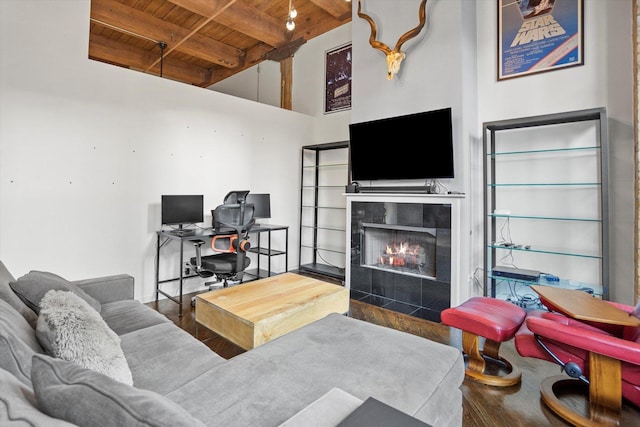 living room featuring beam ceiling, a tile fireplace, hardwood / wood-style floors, and wood ceiling