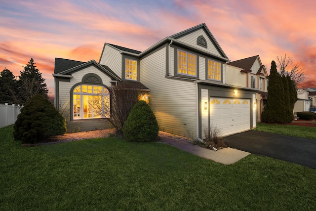 front of property with a garage and a yard