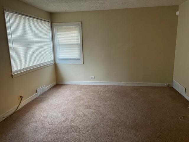 carpeted spare room with a textured ceiling