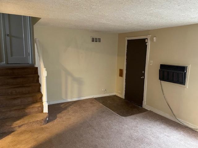 empty room featuring a textured ceiling and carpet flooring