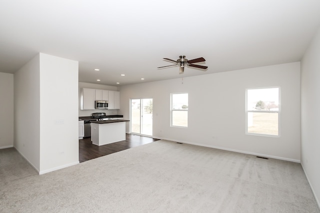 unfurnished living room with carpet flooring and ceiling fan