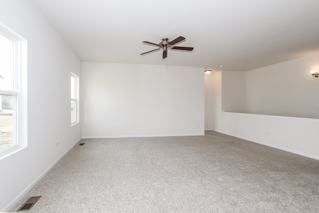 spare room featuring ceiling fan, a healthy amount of sunlight, and carpet floors