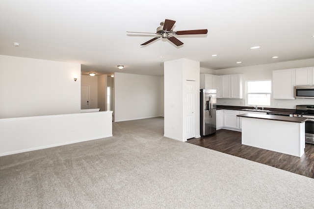 kitchen with white cabinetry, sink, ceiling fan, dark carpet, and stainless steel appliances