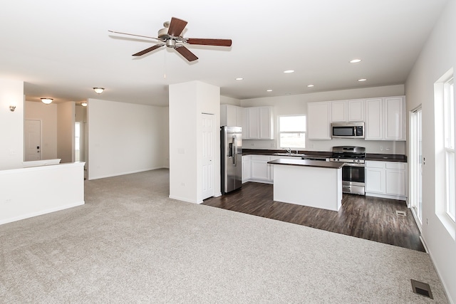 kitchen with white cabinetry, dark colored carpet, ceiling fan, and appliances with stainless steel finishes