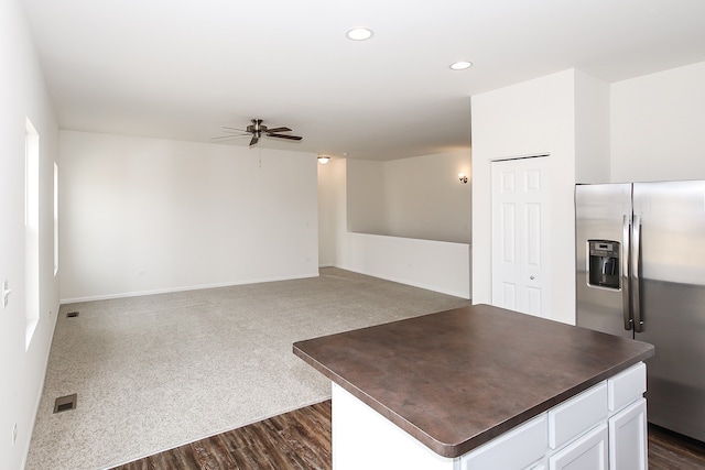 kitchen featuring ceiling fan, dark hardwood / wood-style floors, white cabinets, and stainless steel refrigerator with ice dispenser