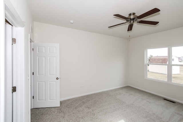 carpeted empty room featuring ceiling fan