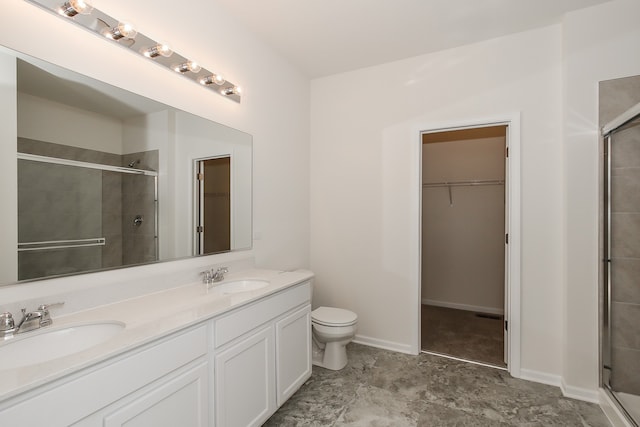 bathroom featuring vanity, toilet, and a shower with shower door