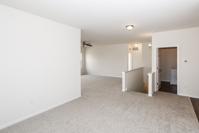 carpeted empty room with ceiling fan and washer / dryer