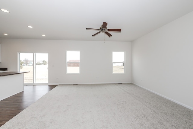 unfurnished living room with dark hardwood / wood-style floors and ceiling fan