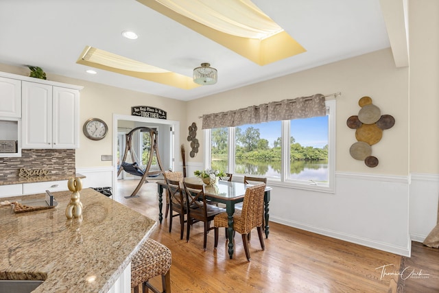 dining room featuring light wood-type flooring and a water view