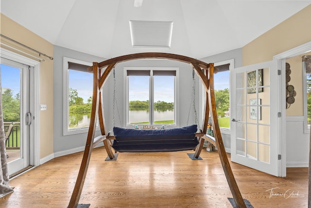 sunroom / solarium with a water view, a wealth of natural light, and lofted ceiling