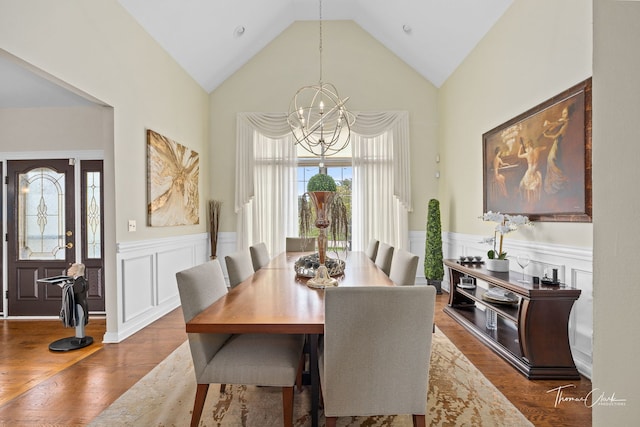 dining area with a notable chandelier, dark wood-type flooring, and high vaulted ceiling