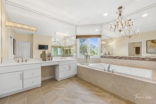 bathroom with a relaxing tiled tub, vanity, and an inviting chandelier